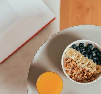 Top view of healthy breakfast with oatmeal, fresh fruit, and orange juice on a tray.