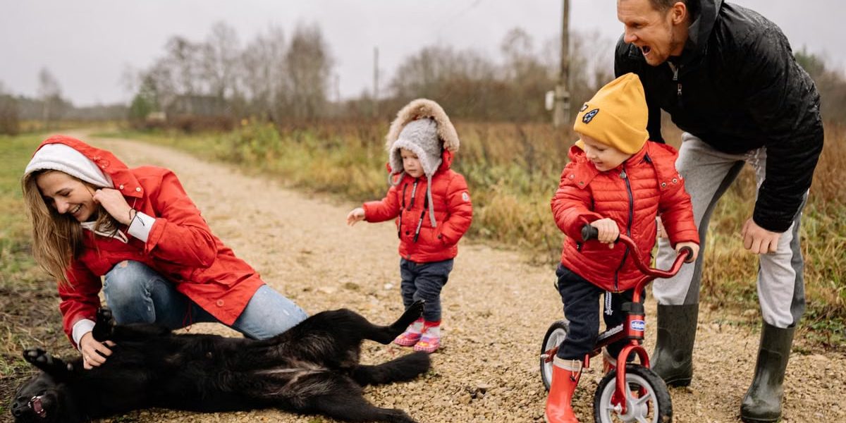 Happy family enjoying quality time outdoors with kids and dog in countryside.